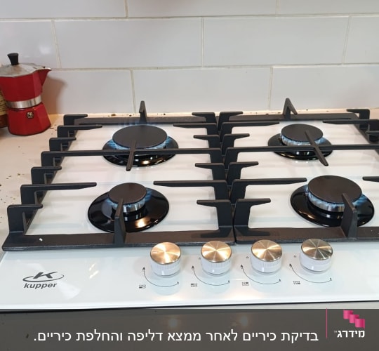 כיריים גז לבנים עם ארבעה מבערים וכפתורי שליטה כסופים